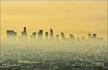  ?? Brian van der Brug Los Angeles Times ?? WILDFIRE SMOKE drifts through the Los Angeles Basin in September. Researcher­s say wildfire smoke now accounts for up to half of all fine-particle pollution in the Western U.S. The long-term health toll is unknown.