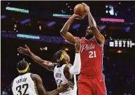  ?? Chris Szagola / Associated Press ?? The 76ers’ Joel Embiid, right, shoots the ball with the Pacers’ Buddy Hield, center, and Terry Taylor, left, defending during the second half on Saturday.