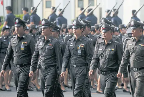  ?? SEKSAN ?? Police officers perform a routine march at the Royal Thai Police headquarte­rs in Bangkok. Police reform should decentrali­se control and allow proper checks and balances.