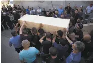  ?? Ariel Schalit / Associated Press ?? Druze men carry the coffin of police officer Hael Sathawi. Druze follow an offshoot of Shiite Islam.