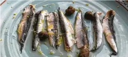  ?? Alison Cook / Staff ?? Marinated anchovies with lemon peel from How to Survive on Land & Sea