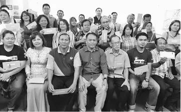  ??  ?? Henry (seated, centre) in a group photo with the recipients of the MRP funds. On his left is Koperasi Kemajuan Singai Bau Bhd chairman Datuk John Tenewi Nuek.