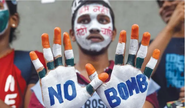  ?? Agence France-presse ?? ↑ A student poses showing his face and hands painted with slogans for peace during a rally to mark Hiroshima Day in Mumbai on Tuesday.