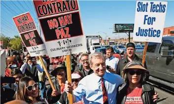  ??  ?? Tom Steyer acompaña a miembros del Sindicato Local 226 de Trabajador­es Culinarios en una protesta afuera del Casino Palms el 19 de febrero