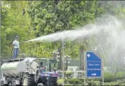  ?? ARVIND YADAV/HT PHOTO ?? A New Delhi Municipal Council employee sprays water on trees in a bid to curb air pollution on Friday.