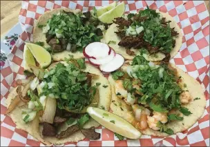  ?? COM LIGAYA FIGUERAS / LFIGUERAS@AJC. ?? At Taquería La Costeñita, tacos come in hand-pressed corn tortillas. The thickness is perfect for bearing generous portions of (clockwise from top left) carne asada, tender, shredded barbacoa, shrimp with a sauteed mix of onions, tomatoes and peppers, or cecina, carne asada’s drier, more seasoned cousin.