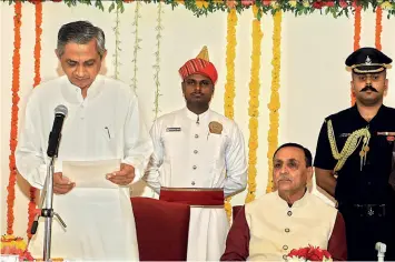  ?? SHAILESH RAWAL ?? WELCOME ADDRESS New minister Kunwarji Bavalia takes oath as CM Rupani looks on