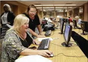  ?? NATI HARNIK / ASSOCIATED PRESS ?? Cheryl Bast (left), of Omaha, Nebraska, is accompanie­d by her daughter, Liz Pierson, as she prepares an applicatio­n for a position with Omaha Public Schools during a job fair in July.