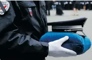  ??  ?? A French police officer holds the hat of slain officer Ahmed Merabet during a ceremony honouring the three officers killed in the terrorist attacks in Paris earlier this month.