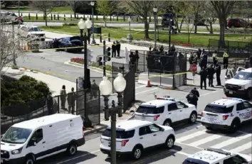  ?? J. Scott Applewhite/Associated Press ?? Police officers gather Friday near the car that a driver rammed into two officers, killing one of them, at a barrier near the U.S. Capitol in Washington.