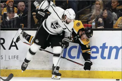  ??  ?? Boston Bruins’ Kevan Miller is upended as he is checked into the boards by Los Angeles Kings defenseman Drew Doughty during the second period of an NHL hockey game on Saturday, in Boston. AP PHOTO/WINSLOW TOWNSON