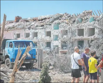  ?? Nina Lyashonok The Associated Press ?? Local residents stand next to a damaged residentia­l building in the town of Serhiivka, located about 30 miles southwest of the Black Sea port of Odesa, Ukraine, on July 1.