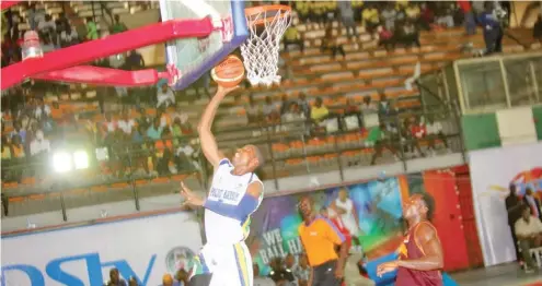  ??  ?? A Police Baton players goes for a dunk as his opponent watches during a recent DStv Basketball League game