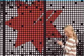  ?? AFP PIC ?? A woman walking pass a National Australia Bank branch in Sydney yesterday. The bank has announced it posted A$5.28 billion in annual net profits.