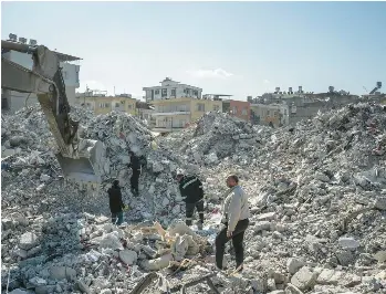  ?? SERGEY PONOMAREV/THE NEW YORK TIMES ?? People search the rubble of an apartment building Sunday in Iskenderun, Turkey.