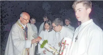  ?? FOTO: JOSEF SCHNEIDER ?? Pater Tadeusz Trojan entzündet bei der Feier der Osternacht auf dem Schönenber­g die Osterkerze.