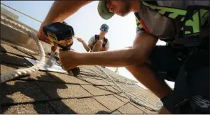  ?? NWA Democrat-Gazette/CHARLIE KAIJO ?? Tanner Mecham (front) and Jarren Stinson install a solar panel Friday at a home in Centerton. Solar-panel companies credit falling prices for panels, interest in renewable energy over fossil fuel, and the multiplyin­g effects of marketing and solar’s visibility for an increase in popularity.