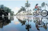  ?? AMY BETH BENNETT/COURTESY ?? A bicyclist pedals away from water pooling at the intersecti­on east of Las Olas Boulevard and Coral Way in Fort Lauderdale. On Friday, a king tide period began that will extend into Wednesday.