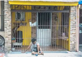  ?? ROMAN PROSPERO ?? Equality still far off Homeless man idly sits outside a gated porch of a middle-sized house. Many Filipinos would be happy to own a lot with just the size of the outer extension of this shelter.