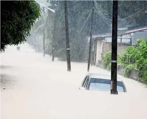  ?? — Bernama ?? Weather woes: A car seen submerged on an inundated street in George Town after heavy rain during the recent floods.