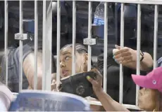  ?? — AFP photo ?? A fan hides under a seat after shots are heard from a shooting outside the stadium which sent players and fans seeking shelter during a baseball game at the Nationals Park in Washington, DC.