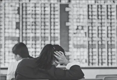  ?? HU GUOLIN / FOR CHINA DAILY ?? Investors check stock prices at a securities brokerage in Jiujiang, Jiangxi province.