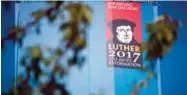  ??  ?? A portrait of Martin Luther is seen on the side of a giant book displaying all the pages of the bible on its back side in the Lutherstad­t Wittenberg.