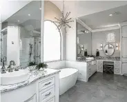  ?? Courtesy of Remodelers of Houston ?? This remodeled master bath features tube sconce lights.