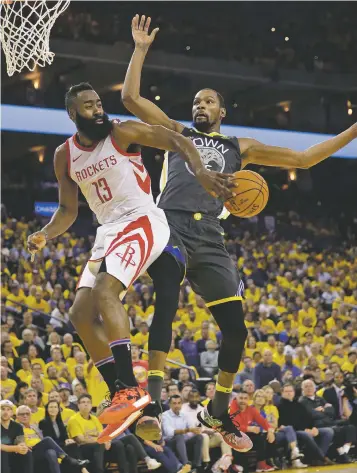  ?? MARCIO JOSE SANCHEZ/ASSOCIATED PRESS ?? Rockets guard James Harden, left, passes behind Warriors forward Kevin Durant during Game 4 of the Western Conference Finals on Tuesday in Oakland, Calif.