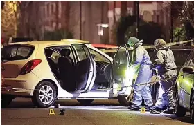  ?? Photo: Daily Mail ?? Forensics at the scene inspect an abandoned white Hyundai i20 hatchback abandoned with its doors open on the street where homes sell for as much as £3million.