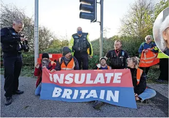  ?? IAN WEST/PA WIRE ?? Above, The Rev Sue Parfitt. Left, police officers speak to protesters at an Insulate Britain roadblock near to the South Mimms roundabout at the junction of the M25 and A1