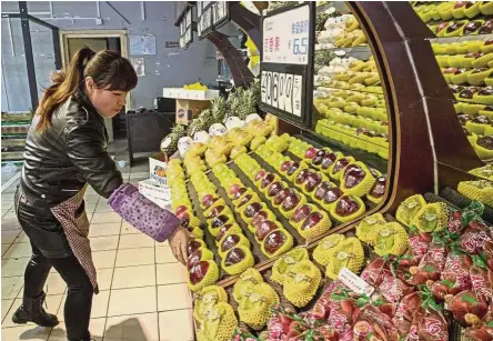  ??  ?? Lost cause: An employee arranging imported American apples for sale at a grocery store in Beijing, President Donald Trump says the US lost a trade war with China ‘years ago’. In a tweet Wednesday after China announced a list of US products that might...