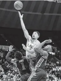  ?? Gerald Herbert / Associated Press ?? LSU guard Skylar Mays, center, goes to the basket against Memphis guard Tyler Harris, left, and forward Kyvon Davenport in the first half of LSU’s victory on Tuesday.