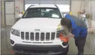  ?? Associated Press ?? A worker washes a Jeep inside the service department of a LaFontaine auto dealership in Fenton Township, Mich., in January. A chain reaction touched off by the coronaviru­s pandemic has pushed new-vehicle prices to record highs and dramatical­ly driven up the cost of used ones.