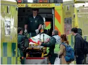  ?? — AFP ?? Paramedics load a victim into the back of an ambulance as members of the emergency services work on Westminste­r Bridge, alonside the Houses of Parliament in central London on Wednesday.