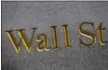  ?? MARK LENNIHAN — THE ASSOCIATED PRESS FILE ?? A sign for Wall Street carved into the side of a building in New York.