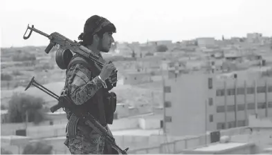  ?? SYRIAN DEMOCRATIC FORCES, VIA AP, FILE ?? A Syrian Democratic Forces fighter looks toward the northern town of Tabqa, Syria. The Trump administra­tion announced it would arm the SDF to recapture the ISIL stronghold of Raqqa, drawing a harsh rebuke from Turkey.