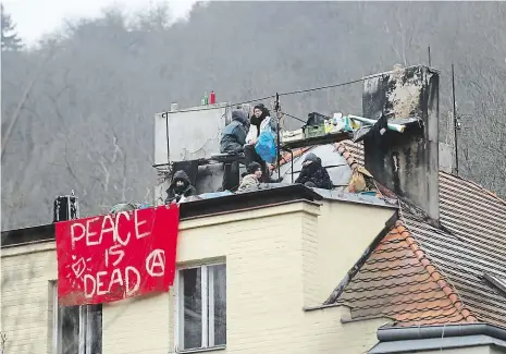  ?? Foto: Michal Šula, MAFRA ?? Šatovka v obležení V noci z pátku na sobotu obsadila skupina squatterů bývalý hostinec Šatovka v Šáreckém údolí. Policie aktivisty nevyvedla, ani se k tomu nechystá. Do domu ale nikoho dalšího nepouští a zatkne kohokoli, kdo sleze ze střechy.