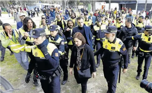  ?? JAIME GALINDO ?? ABANDONO ENTRE INSULTOS.
Sara Fernández sale del parque rodeada de policías y con varios huelguista­s increpándo­le (izda.)