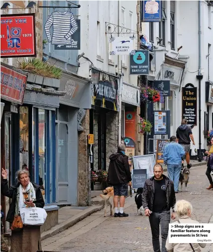  ?? Greg Martin ?? > Shop signs are a familiar feature along pavements in St Ives