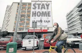  ?? /Esa Alexander (More inside) ?? Awareness notice: A ‘Stay Home’ billboard is installed on Wednesday on an apartment building on the corner of Long and Kloof streets in Cape Town, before the country goes into a nationwide lockdown for 21 days from Friday to slow the spread of the coronaviru­s.