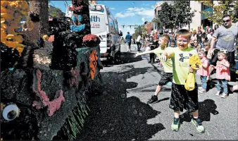  ??  ?? Kids play in bubbles along the parade route during the festival on Saturday.