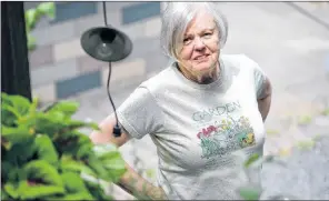  ?? AP PHOTO ?? Anne Hunt stands in her garden at her home in Chicago on July 13. Since Hunt’s Alzheimer’s diagnosis in 2016, she has started gardening as a form of therapy.