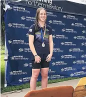  ?? ?? Isobel Nash stands proudly after finishing second in her 50m breaststro­ke event. She achieved a national qualifying time with her swim.