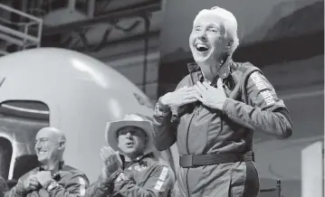  ?? TONY GUTIERREZ AP ?? Mark Bezos, left, and Jeff Bezos, center, founder of Amazon and space tourism company Blue Origin, applaud as Wally Funk, right, describes their flight experience from the spaceport near Van Horn, Texas, on Tuesday.