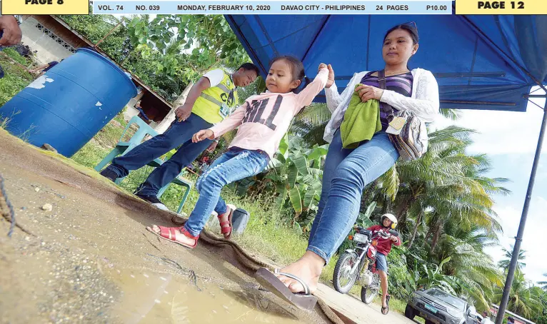  ?? BING GONZALES ?? RESIDENTS step on the footbath for mandatory disinfecti­on at the checkpoint in Lacson, a barangay adjacent to the two areas affected by the African Swine Fever (ASF) in Calinan District.