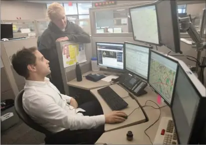  ?? DAVID BEBEE, RECORD STAFF ?? Waterloo Regional Police communicat­ions trainer and analyst Joanne Miranda talks with dispatcher Jason Causton.