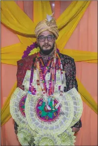  ??  ?? Saqib Fazili, a Kashmiri groom, poses for photograph during a wedding ceremony.