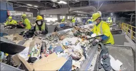  ?? PAUL BERSEBACH — STAFF PHOTOGRAPH­ER ?? Workers at Republic Services in Anaheim last week conduct a pre-sorting, in which they remove items that can’t be recycled.