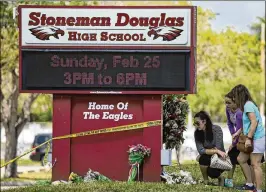  ?? DAVID SANTIAGO / MIAMI HERALD ?? Mourners bring flowers as they pay tribute at a memorial for the victims of the shooting at Marjory Stoneman Douglas High School on Feb. 25 during an open house. Confessed shooter Nikolas Cruz has pleaded not guilty.